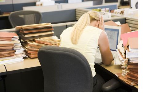Tired businesswoman with stacks of files